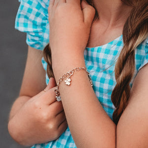 Girl in a Blue and White checked dress wearing our Children's Elephant Charm on chain of hearts charm bracelet 