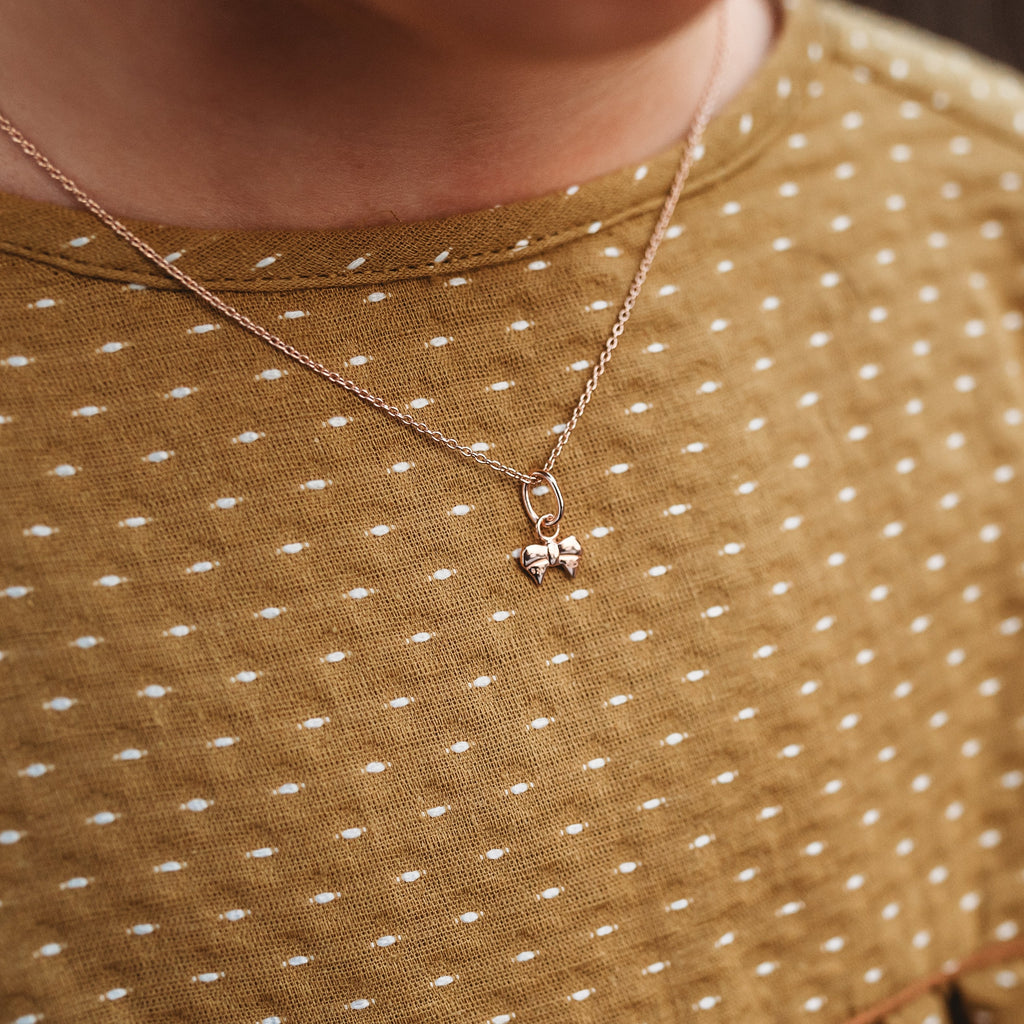 Ribbon Bow Pendant in Rose Gold Vermeil worn on a tween girl n a mustard dress